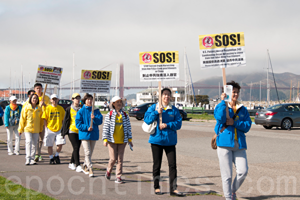 10月23日，一來自全球各國的部份法輪功學員近二千人分散在舊金山市區的46個公園、廣場和地標景點，集體煉功、反對活摘器官遊行和講真相徵簽。圖為沿著漁人碼頭等海濱行進的隊伍（周鳳臨／大紀元）