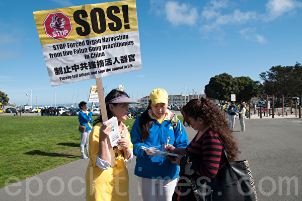 10月23日，一來自全球各國的部份法輪功學員近二千人分散在舊金山市區的46個公園、廣場和地標景點，集體煉功、反對活摘器官遊行和講真相徵簽。圖為沿著漁人碼頭等海濱行進的隊伍（周鳳臨／大紀元）