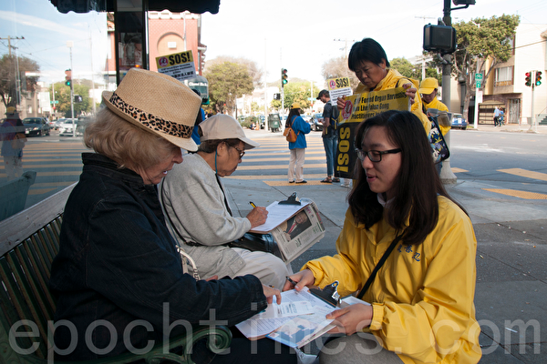 10月23日，一來自全球各國的部份法輪功學員近二千人分散在舊金山市區的46個公園、廣場和地標景點，集體煉功、反對活摘器官遊行和講真相徵簽。圖為沿著漁人碼頭等海濱行進的隊伍（周鳳臨／大紀元）